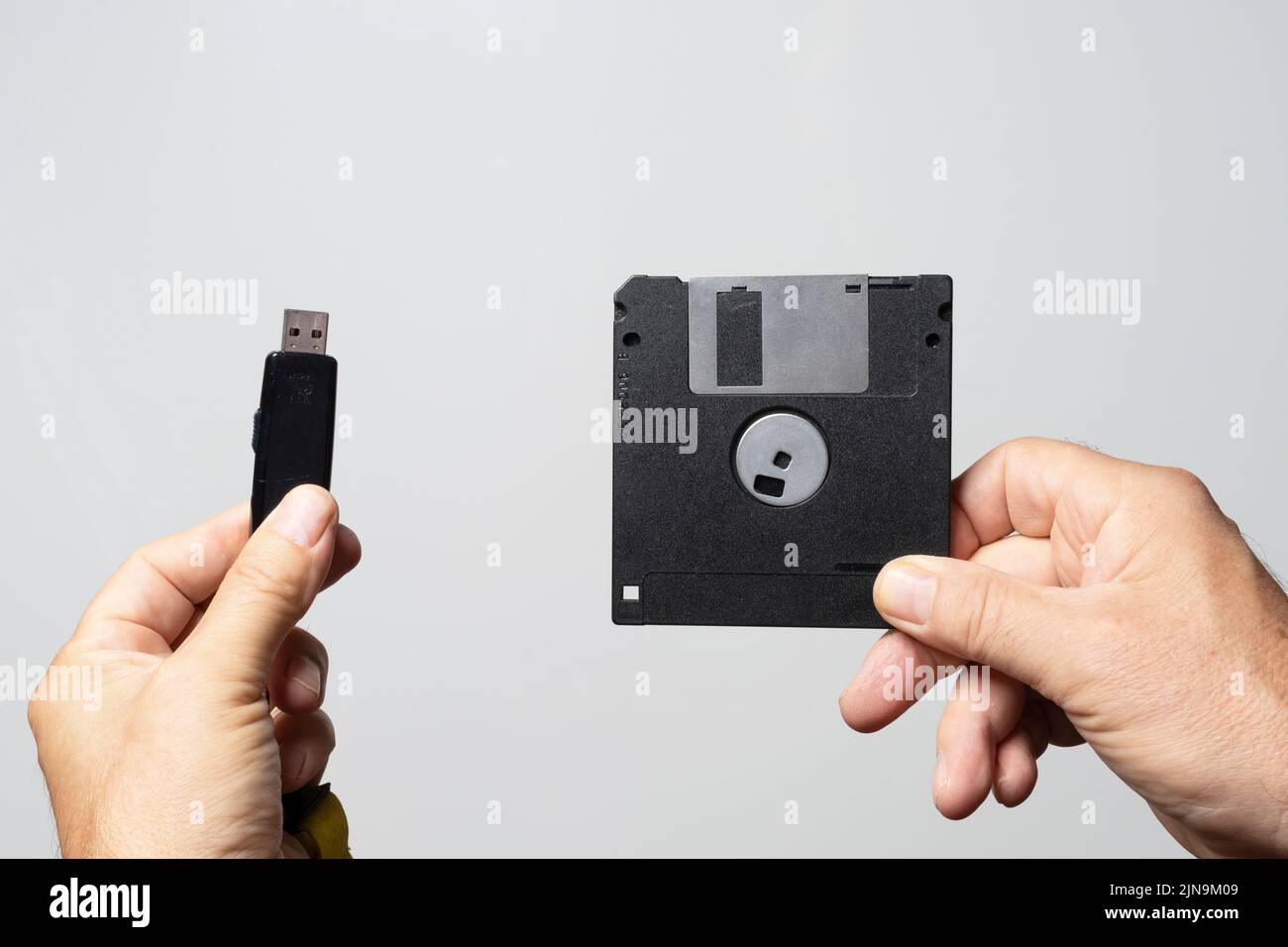 Il confronto tra un vecchio disco floppy e una chiave USB per la memorizzazione dei dati Foto Stock