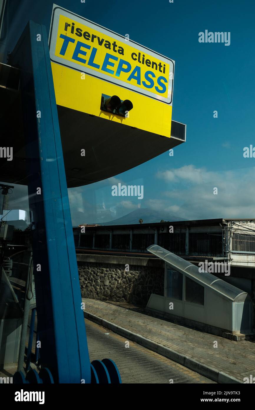 Segnali stradali a pedaggio Telepass come si vede passare da una finestra di un pullman che attraversa l'Italia vicino a Pompei. Foto Stock