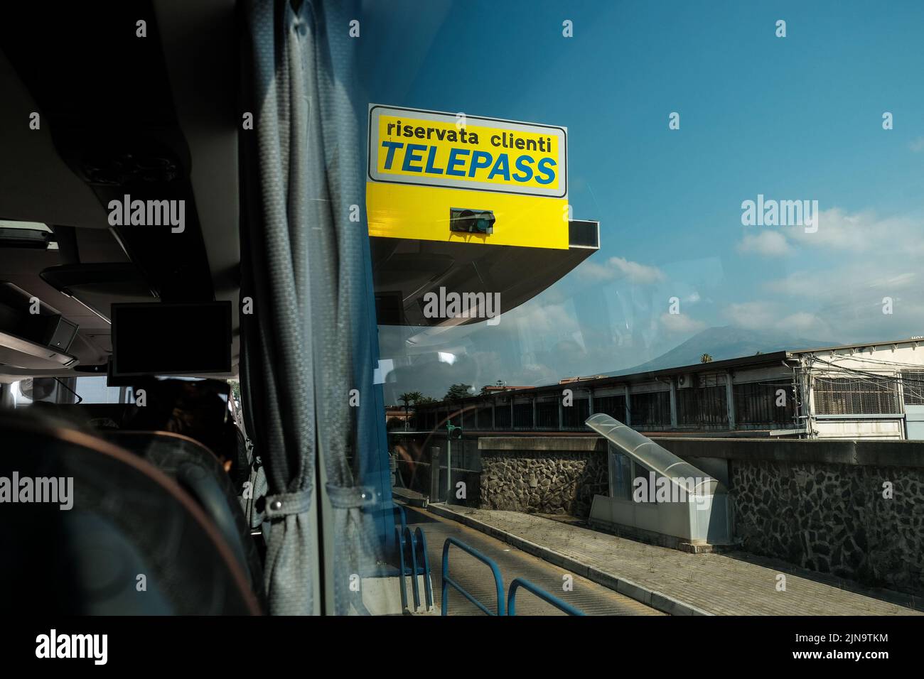 Segnali stradali a pedaggio Telepass come si vede passare da una finestra di un pullman che attraversa l'Italia vicino a Pompei. Foto Stock