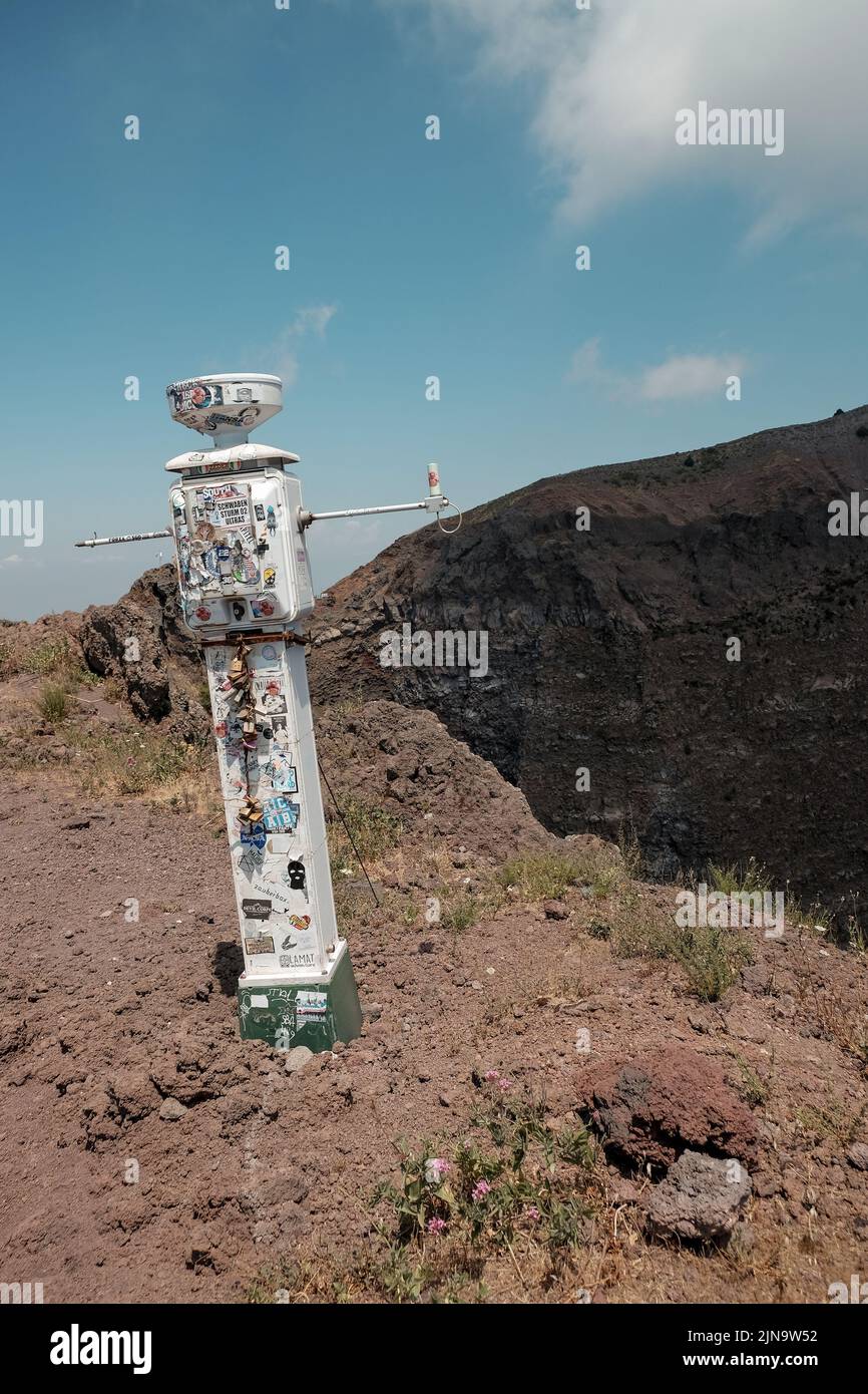 Lucchetti d'amore e adesivi turistici su uno strumento di misura scientifico sul Vesuvio sul bordo del cratere del vulcano attivo in Italia. Foto Stock