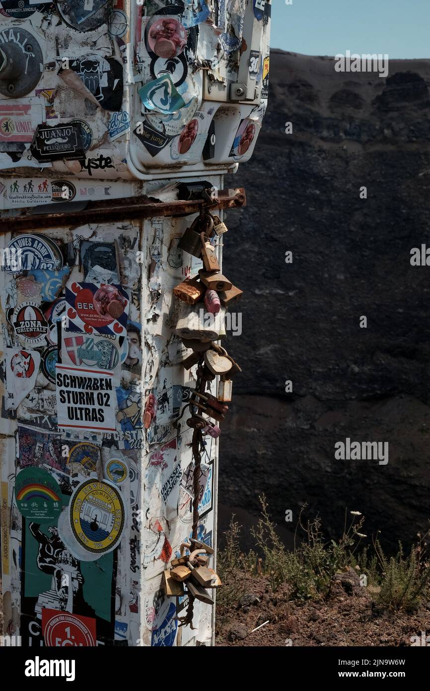 Lucchetti d'amore e adesivi turistici su uno strumento di misura scientifico sul Vesuvio sul bordo del cratere del vulcano attivo in Italia. Foto Stock