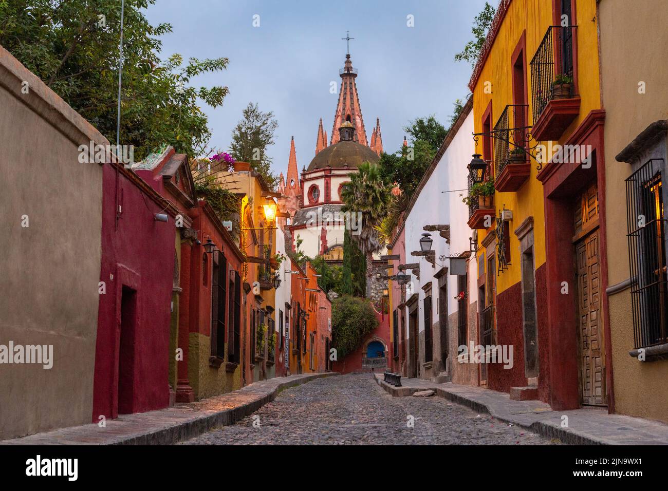 Vista di mattina presto della Calle Aldama di ciottoli della torre barque originale di Parroquia de San Miguel Arcangel nel centro storico della città di San Miguel de Allende, Messico. Foto Stock