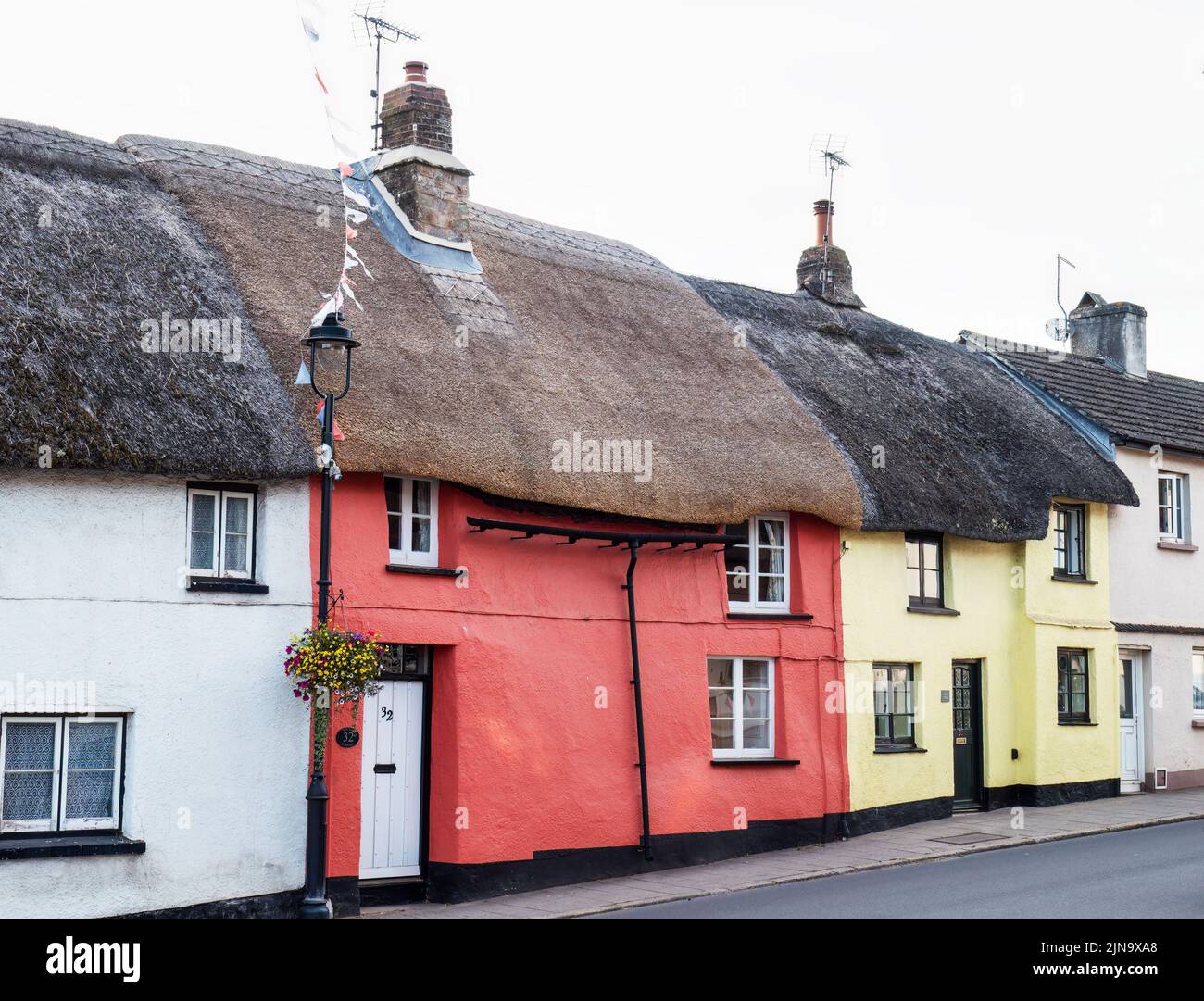 Bella fila di case con tetto in paglia a Hatherleigh, Devon, Regno Unito. Foto Stock