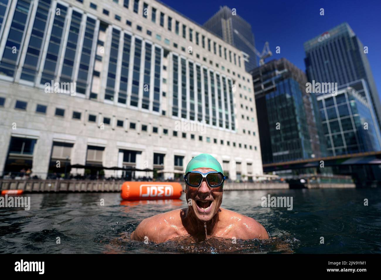 Un nuotatore nel nuovo luogo di nuoto all'aperto a Canary Wharf durante il clima caldo nella parte est di Londra. L'ufficio MET ha emesso un avvertimento color ambra per il calore estremo che copre quattro giorni da giovedì a domenica per alcune parti dell'Inghilterra e del Galles come nuovi telai ad onda calda. Data foto: Mercoledì 10 agosto 2022. Foto Stock