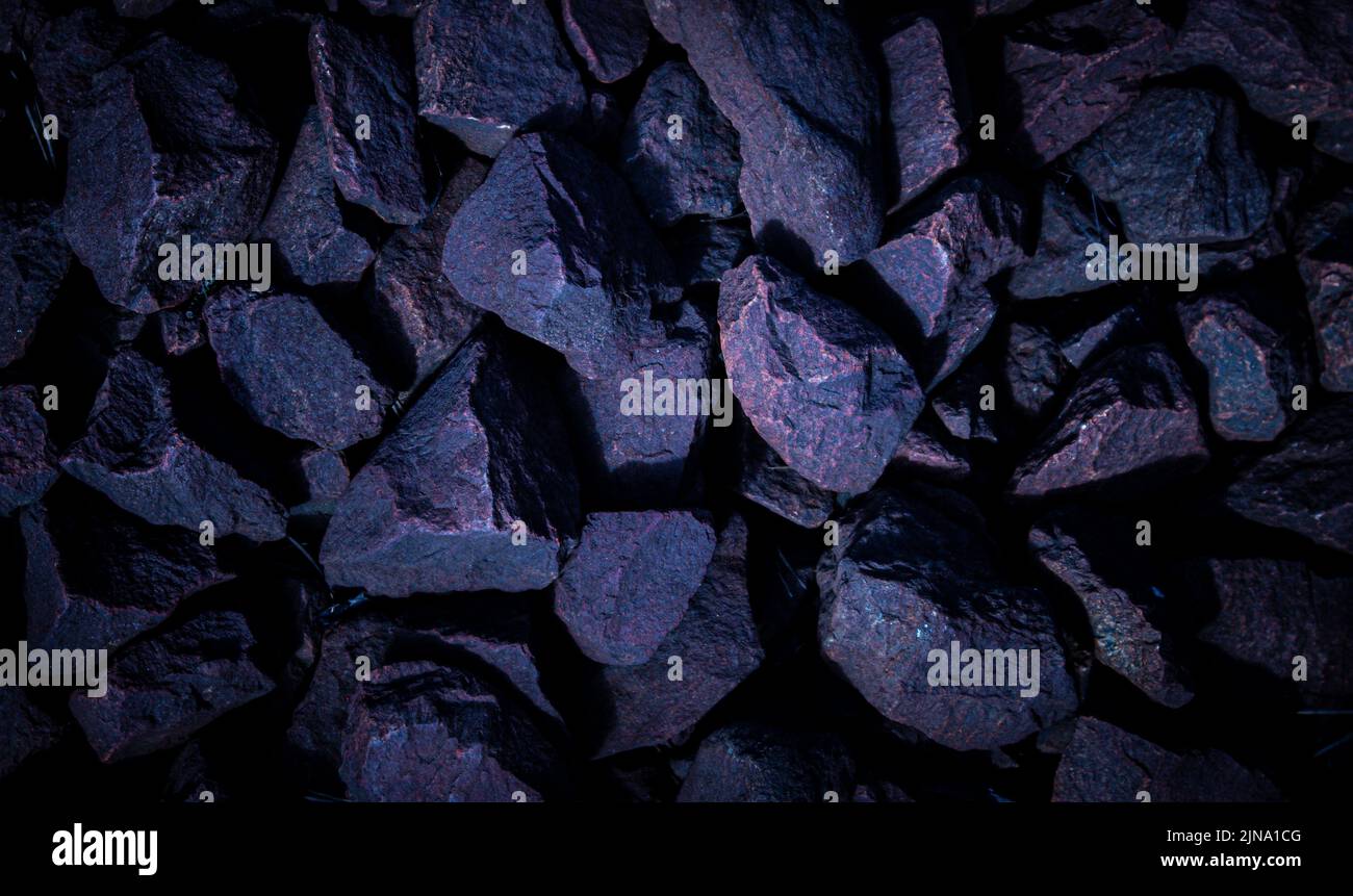 Rocce rosa-viola scintillanti texture, sfondo, carta da parati. Atmosfera scura con parte centrale chiara. Foto Stock