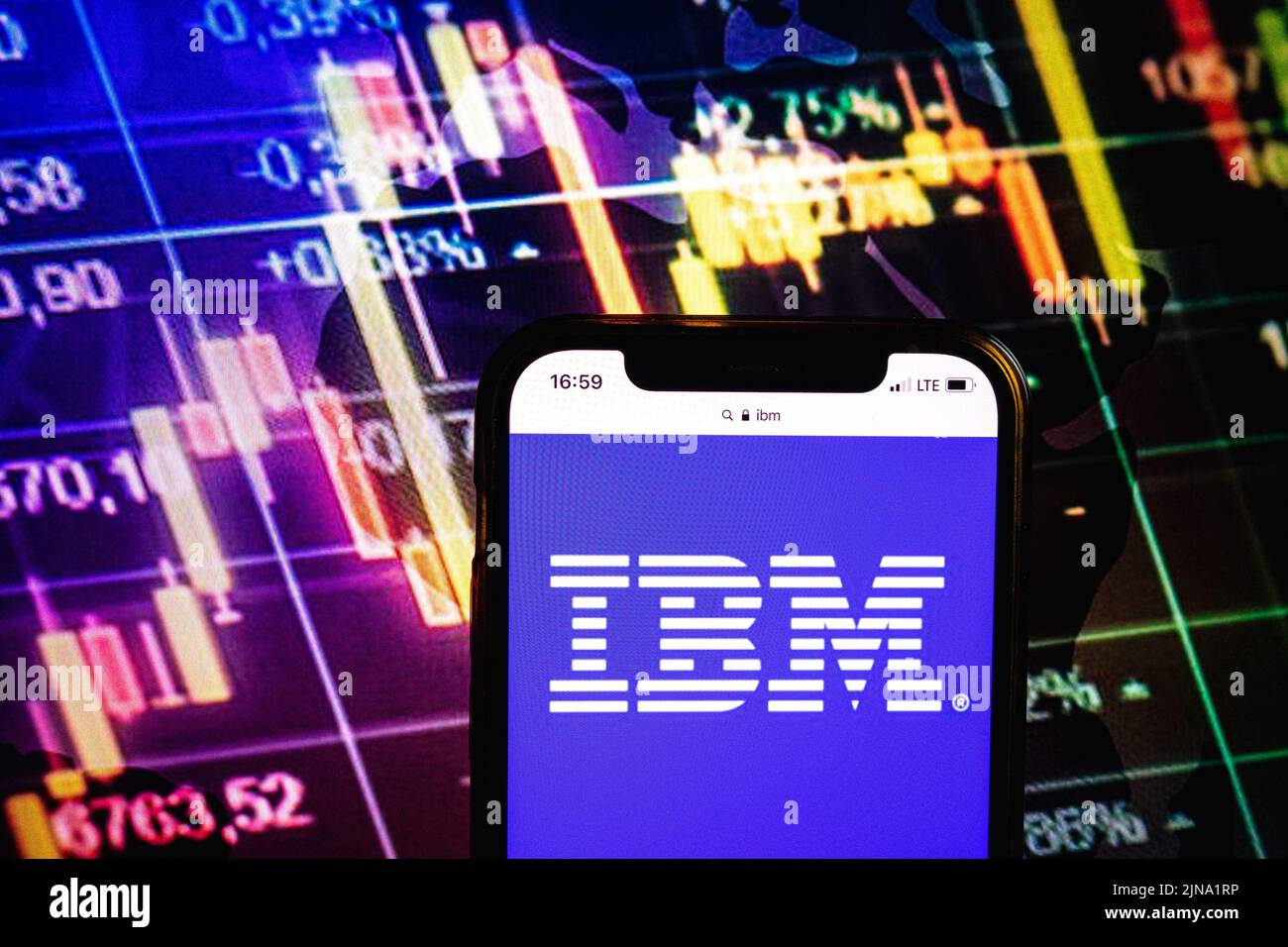 KONSKIE, POLONIA - 09 agosto 2022: Smartphone che mostra il logo della società IBM sullo sfondo del diagramma di borsa Foto Stock