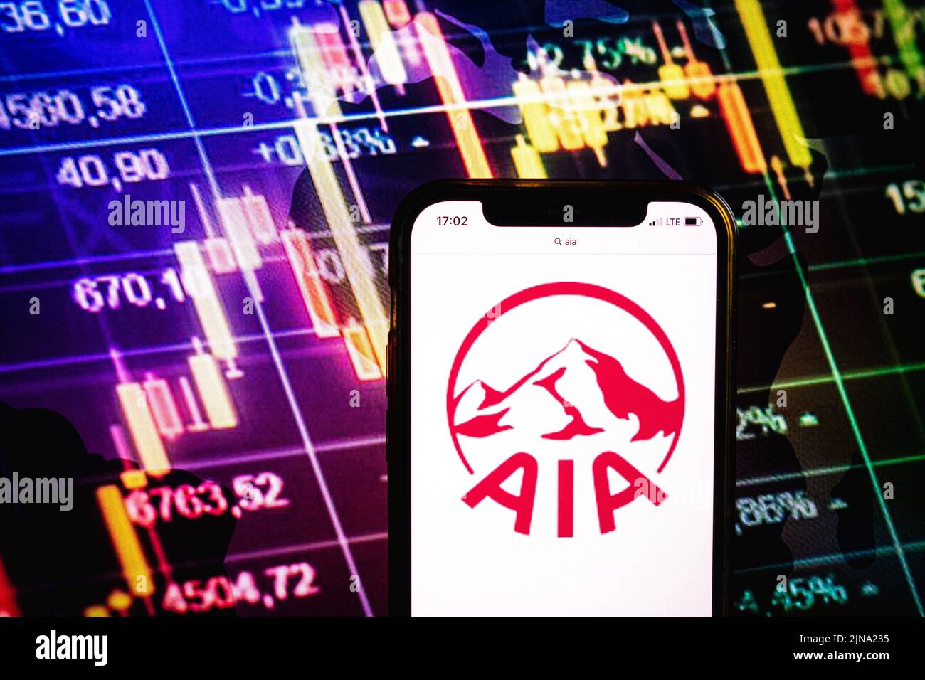 KONSKIE, POLONIA - 09 agosto 2022: Smartphone che mostra il logo della società AIA Group Ltd sullo sfondo del diagramma di borsa Foto Stock