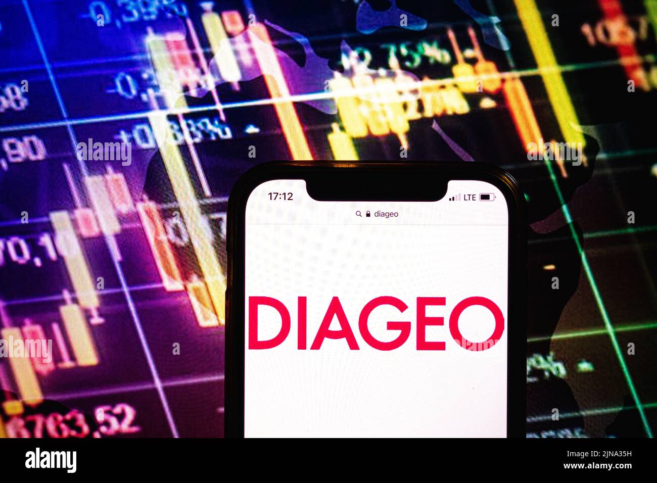 KONSKIE, POLONIA - 09 agosto 2022: Smartphone che mostra il logo della società Diageo sullo sfondo del diagramma di borsa Foto Stock
