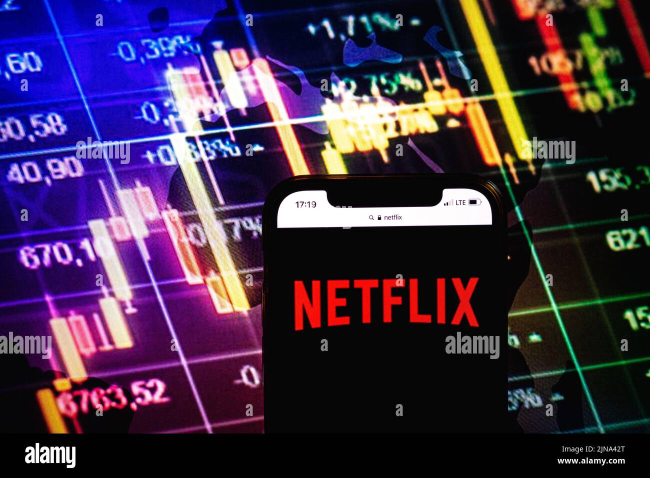 KONSKIE, POLONIA - 09 agosto 2022: Smartphone che mostra il logo della società Netflix sullo sfondo del diagramma di borsa Foto Stock