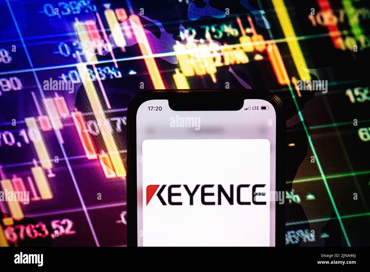 KONSKIE, POLONIA - 09 agosto 2022: Smartphone che mostra il logo della società KEYENCE sullo sfondo del diagramma di borsa Foto Stock