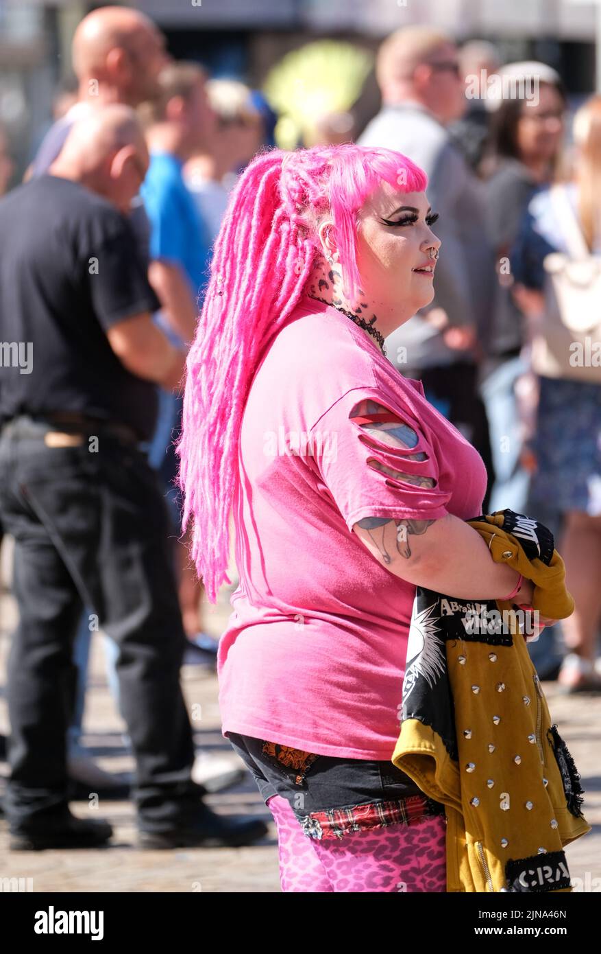 Blackpool, Lancashire, UK Agosto 6 2022 Una vista laterale di una giovane donna che indossa capelli e vestiti rosa brillante durante il Blackpool Rebellion Punk Festival Foto Stock Blackpool, Lancashire, UK Agosto 6 2022 Una vista laterale di una giovane donna che indossa capelli e vestiti rosa brillante durante il Blackpool Rebellion Punk Festival Foto Stock