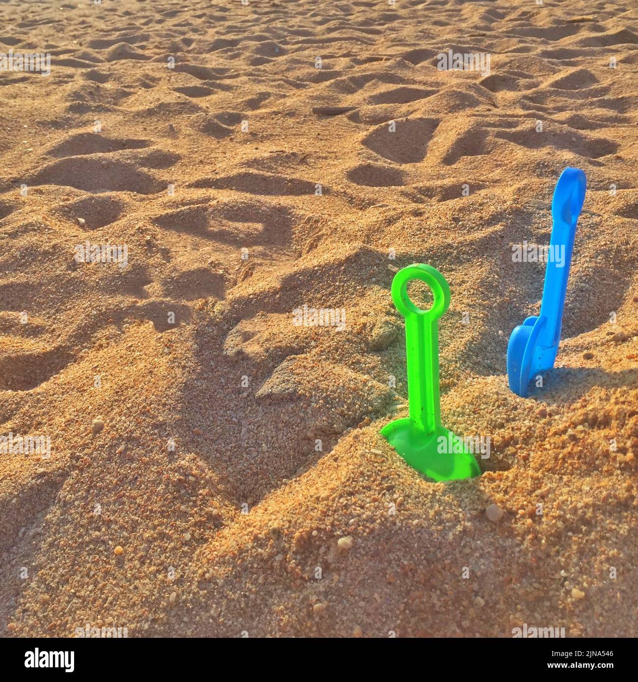 Primo piano di due pale in plastica nella sabbia su una spiaggia, Italia Foto Stock