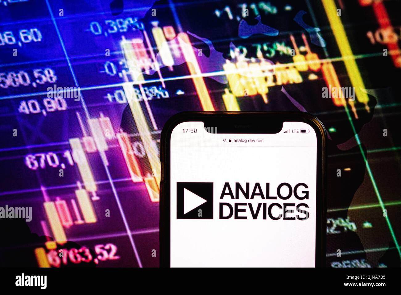 KONSKIE, POLONIA - 09 agosto 2022: Smartphone che mostra il logo della società Analog Devices sullo sfondo del diagramma di borsa Foto Stock