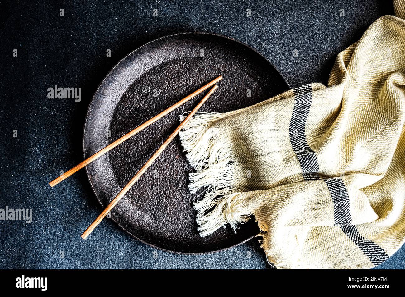 Vista dall'alto di una coppia di bacchette e di un pattino del tavolo su una piastra metallica Foto Stock