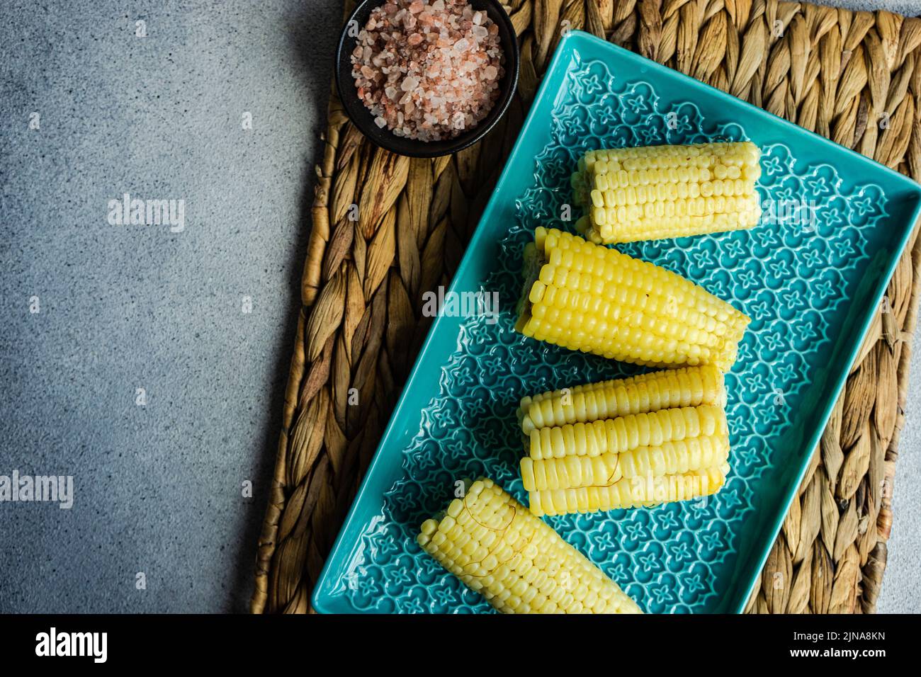 Vista dall'alto di pannocchie di mais bollite fresche con sale himalayano rosa Foto Stock