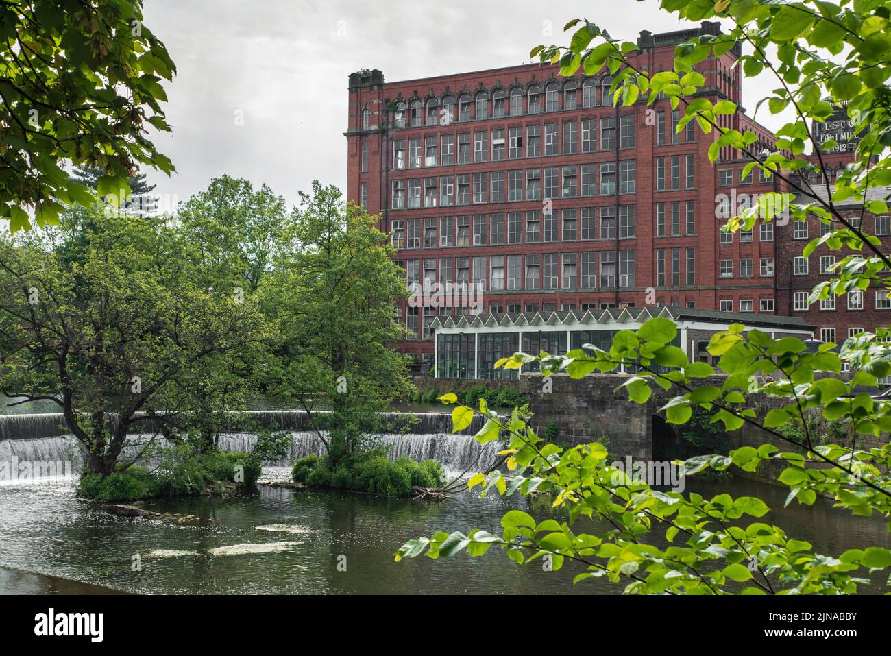 L'East Mill e lo strizzone a ferro di cavallo sul fiume Derwent a Belper, Derbyshire, Regno Unito Foto Stock