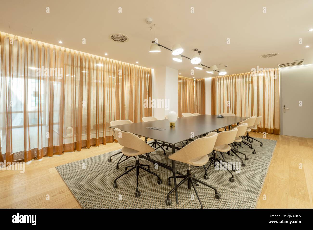 Sala riunioni di un ufficio professionale a parete e sedie girevoli nere con rivestimento leggero Foto Stock