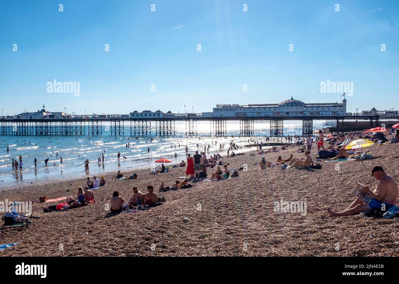 Brighton UK 10th Agosto 2022 - Brighton Beach è piena di persone alla fine di una giornata di sole caldo e bruciante come un'altra ondata di calore inizia con un avvertimento color ambra che viene emesso in parti del Sud-Est : Credit Simon Dack / Alamy Live News Foto Stock