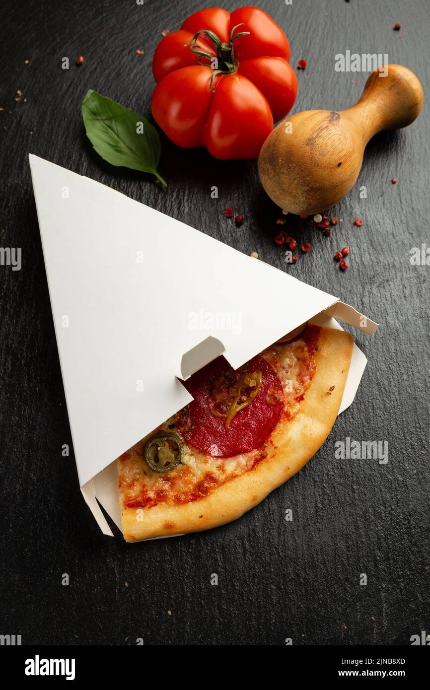 Pezzo di pizza salame in una scatola Foto Stock