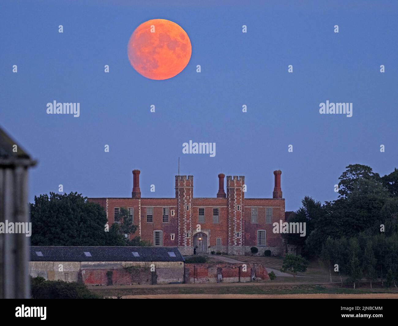 Eastchurch, Kent, Regno Unito. 10th ago, 2022. UK Weather: La quasi piena luna di Sturgeon - l'ultima superluna del 2022 - visto salire sopra la storica casa di guardia Shurland Hall a Eastchurch, Kent. Credit: James Bell/Alamy Live News Foto Stock