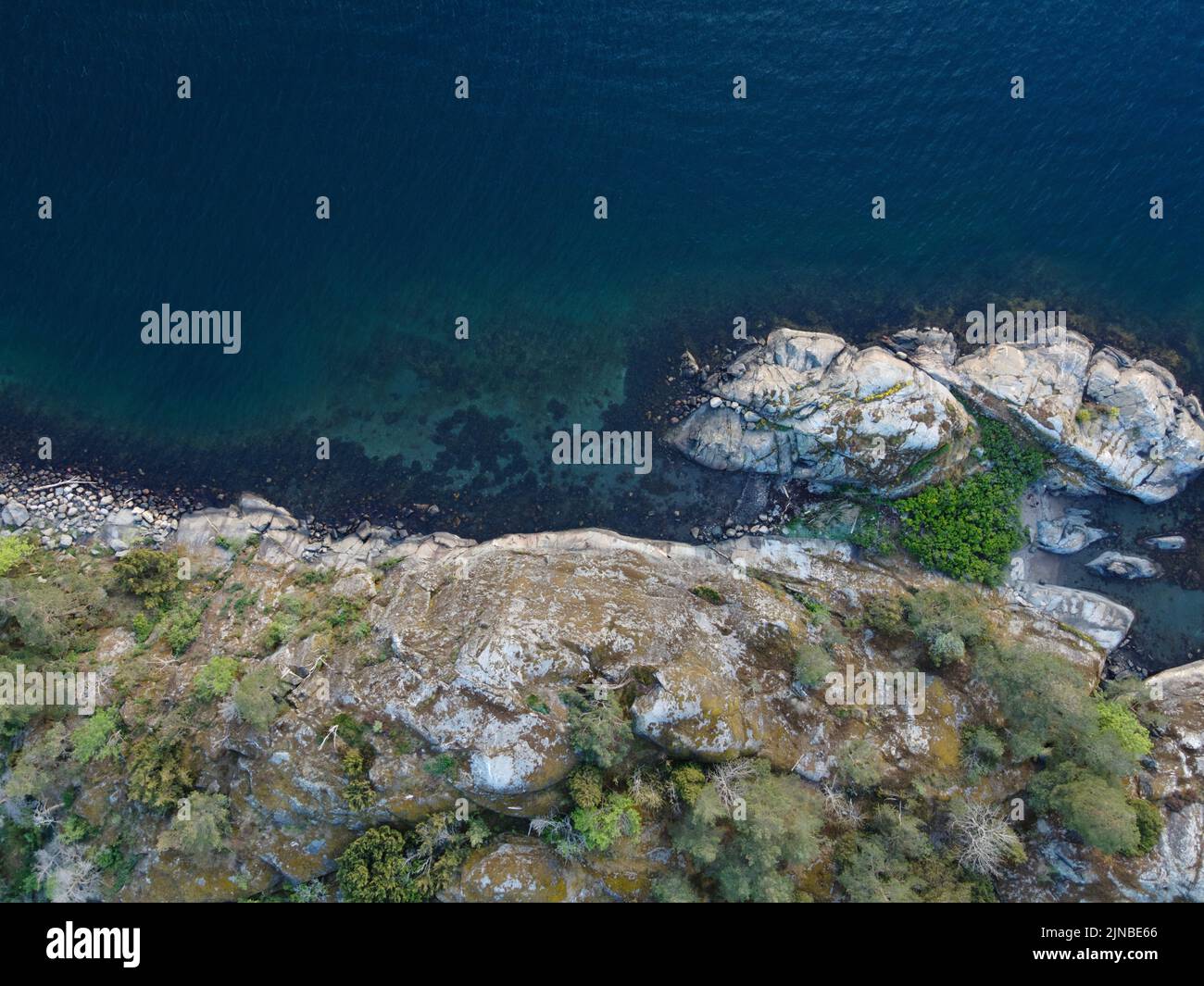 Una vista aerea di un paesaggio costiero con scogliere rocciose e il mare Foto Stock