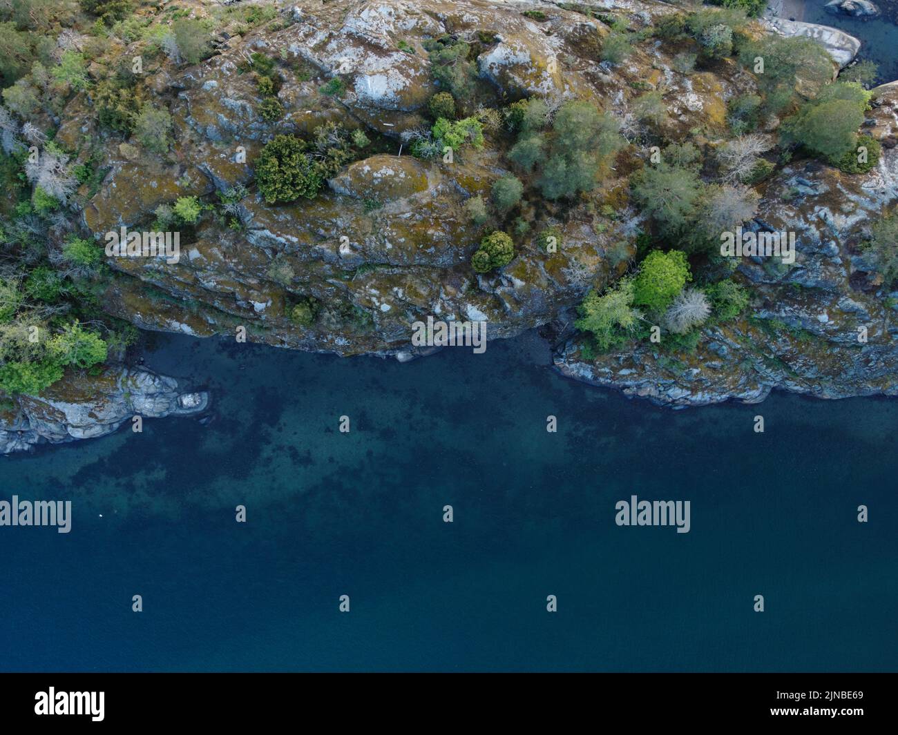 Una vista aerea di un paesaggio costiero con scogliere rocciose e il mare Foto Stock