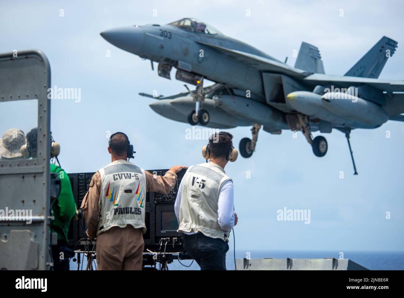 Oceano Pacifico, Stati Uniti. 09th ago 2022. I marinai della Marina degli Stati Uniti guardano un aereo da caccia F/A-18E Super Hornet attaccato alle aquile di Strike Fighter Squadron 115, atterrano sul ponte di volo della portaerei di classe Nimitz USS Ronald Reagan in corso, 9 agosto 2022 nel Mare delle Filippine. Credit: MC3 Gibson/Planetpix/Alamy Live News Credit: Planetpix/Alamy Live News Foto Stock