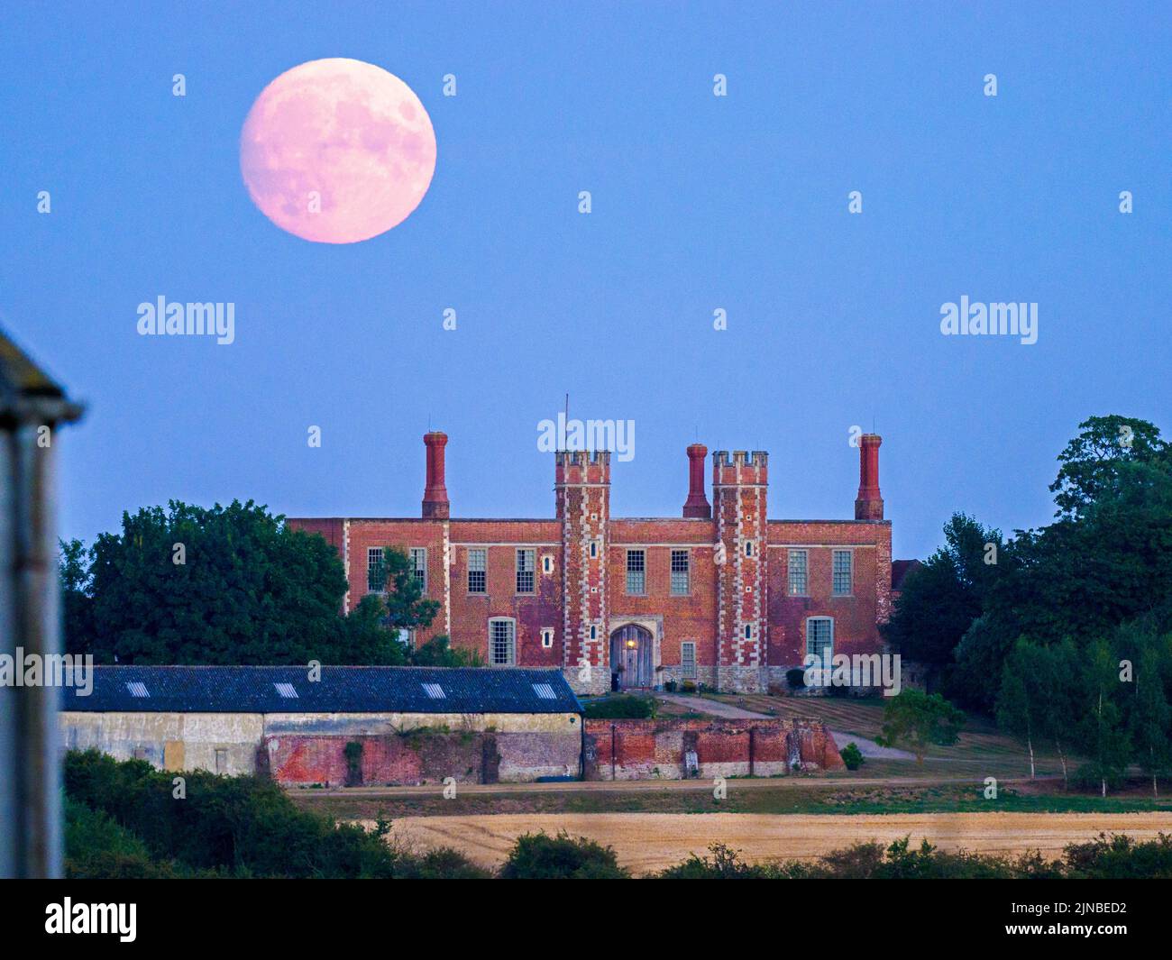 Eastchurch, Kent, Regno Unito. 10th ago, 2022. UK Weather: La quasi piena luna di Sturgeon - l'ultima superluna del 2022 - visto salire sopra la storica casa di guardia Shurland Hall a Eastchurch, Kent. Credit: James Bell/Alamy Live News Foto Stock