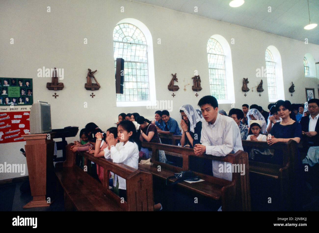 Congregazione coreana in preghiera alla Messa nella Chiesa cattolica di St Ann Kingston London Inghilterra Foto Stock