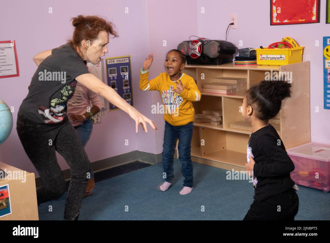 Istruzione Preschool cura dei bambini dai 4 anni in su insegnante di yoga che lavora con un piccolo gruppo di ragazze Foto Stock
