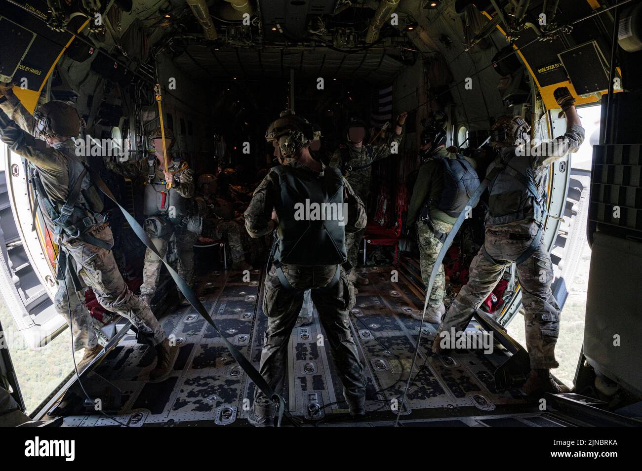 Due loadamstasters dell'aeronautica degli Stati Uniti assegnati alle porte laterali aperte dell'ala delle operazioni speciali 352d per preparare un salto di linea statico con i membri di servizio dal gruppo speciale delle forze dell'esercito degli Stati Uniti 10th (Airborne) e i membri del Zapovjedništvo specijalnih snaga (comando speciale delle forze dell'operazione croata) Da un'aeronautica degli Stati Uniti MC-130J Commando II assegnato alla SOW 352d vicino Udbina, Croazia, 20 luglio 2022. Il salto di linea statico faceva parte di un Joint Combined Exchange Training (JCET), che comprendeva membri della U.S. Air Force's 352d Special Operations Wing, The U.S. Army's 1st Battaglione, 10th Special Foto Stock