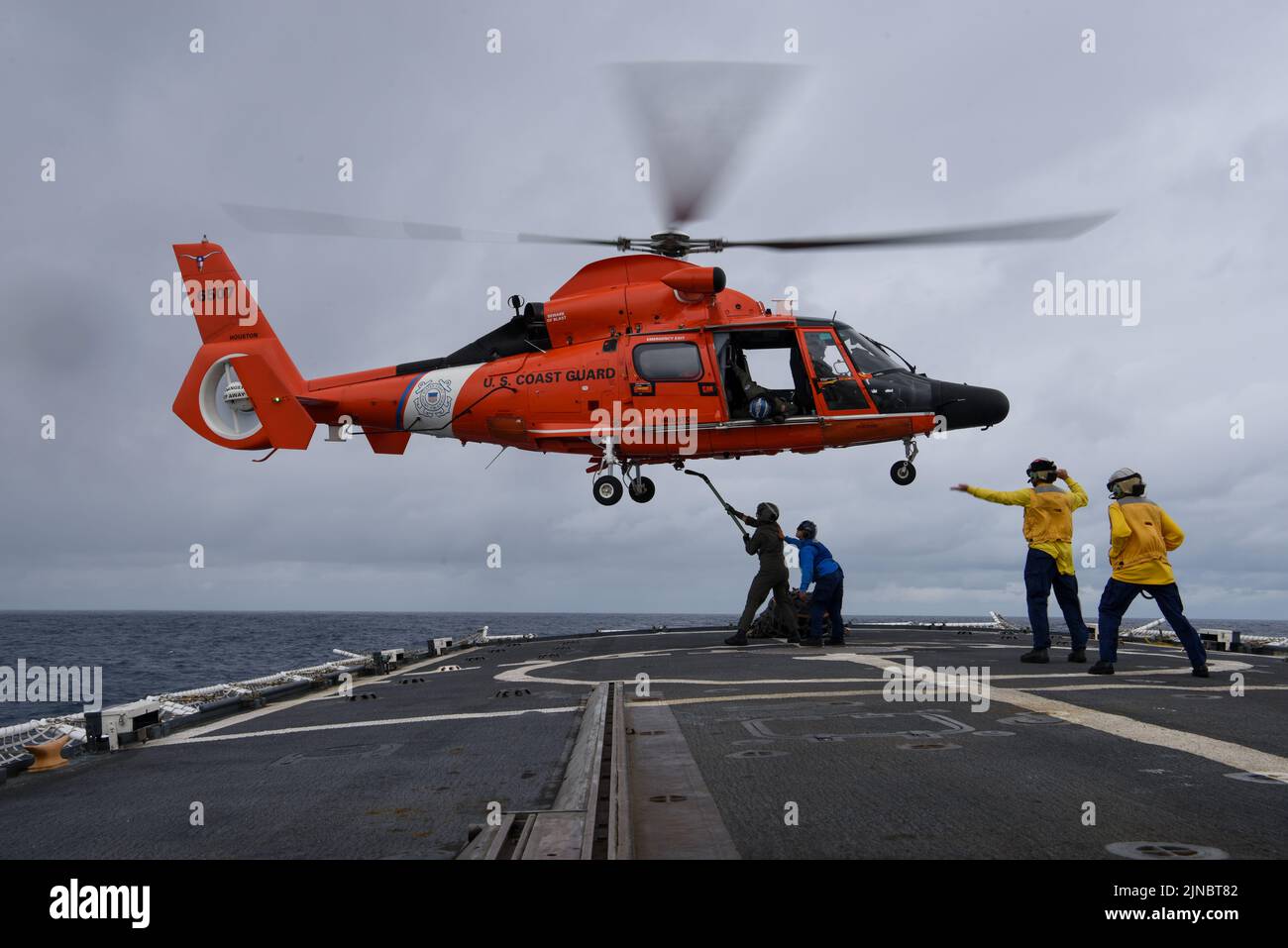 U.S. Coast Guard Petty Officer 1st Classe Josh Trammer, a sinistra, un tecnico di manutenzione Aviazione assegnato alla Stazione aerea della Guardia Costiera di Houston, collega l'imbracatura di sollevamento al gancio di carico dell'elicottero durante le operazioni di rifornimento verticale (VERTREP) con l'equipaggio MH-65 Delfino elicottero a bordo della famosa taglierina di resistenza media USCGC Mohawk (WMEC 913) in corso nell'Oceano Atlantico, 7 agosto 2022. USCGC Mohawk è in fase di dispiegamento programmato nell'area delle operazioni delle forze navali degli Stati Uniti in Africa, impiegata dalla U.S. Sesta flotta per difendere gli interessi degli Stati Uniti, degli alleati e dei partner. (STATI UNITI Guardia costiera Foto Stock