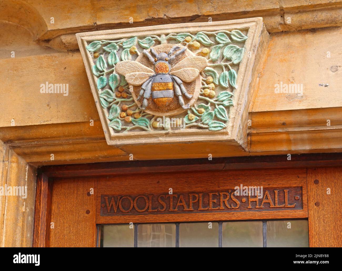 Storico Woolstaplers hall, ingresso in legno intagliato, ape operaia, Chipping Camden, Cotswolds città mercato, Cotswold, Oxfordshire, INGHILTERRA, REGNO UNITO, GL55 6AA Foto Stock