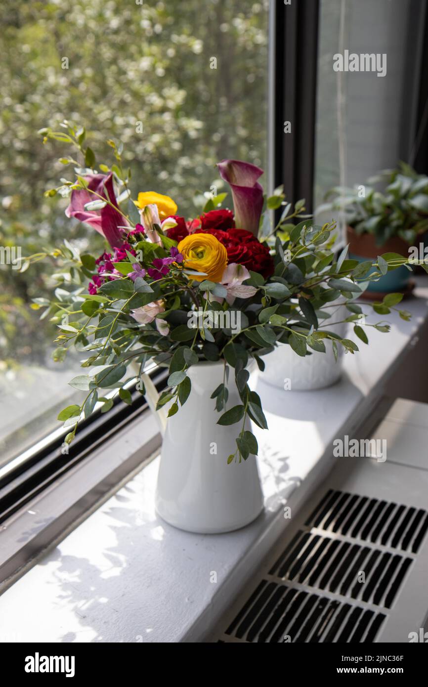 Composizione floreale con giglio di calla, ranuncolo ed eucalipto Foto Stock