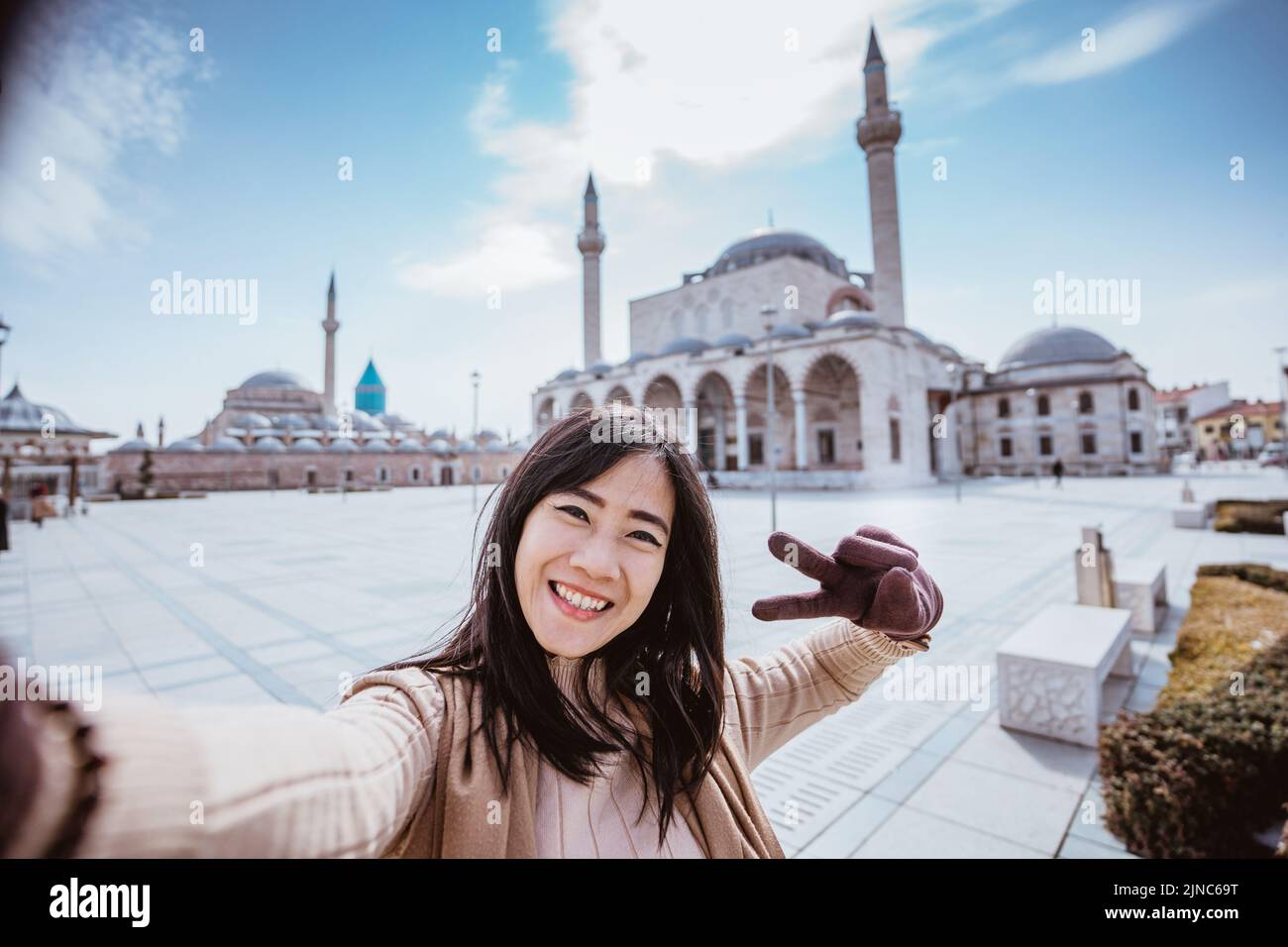 donna che prende selfie ritratto di fronte alla moschea di konya Foto Stock