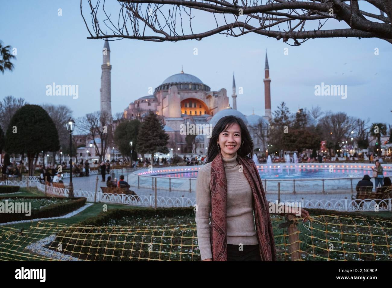 donna sorridente alla macchina fotografica mentre si trova davanti a hagia sophia Foto Stock