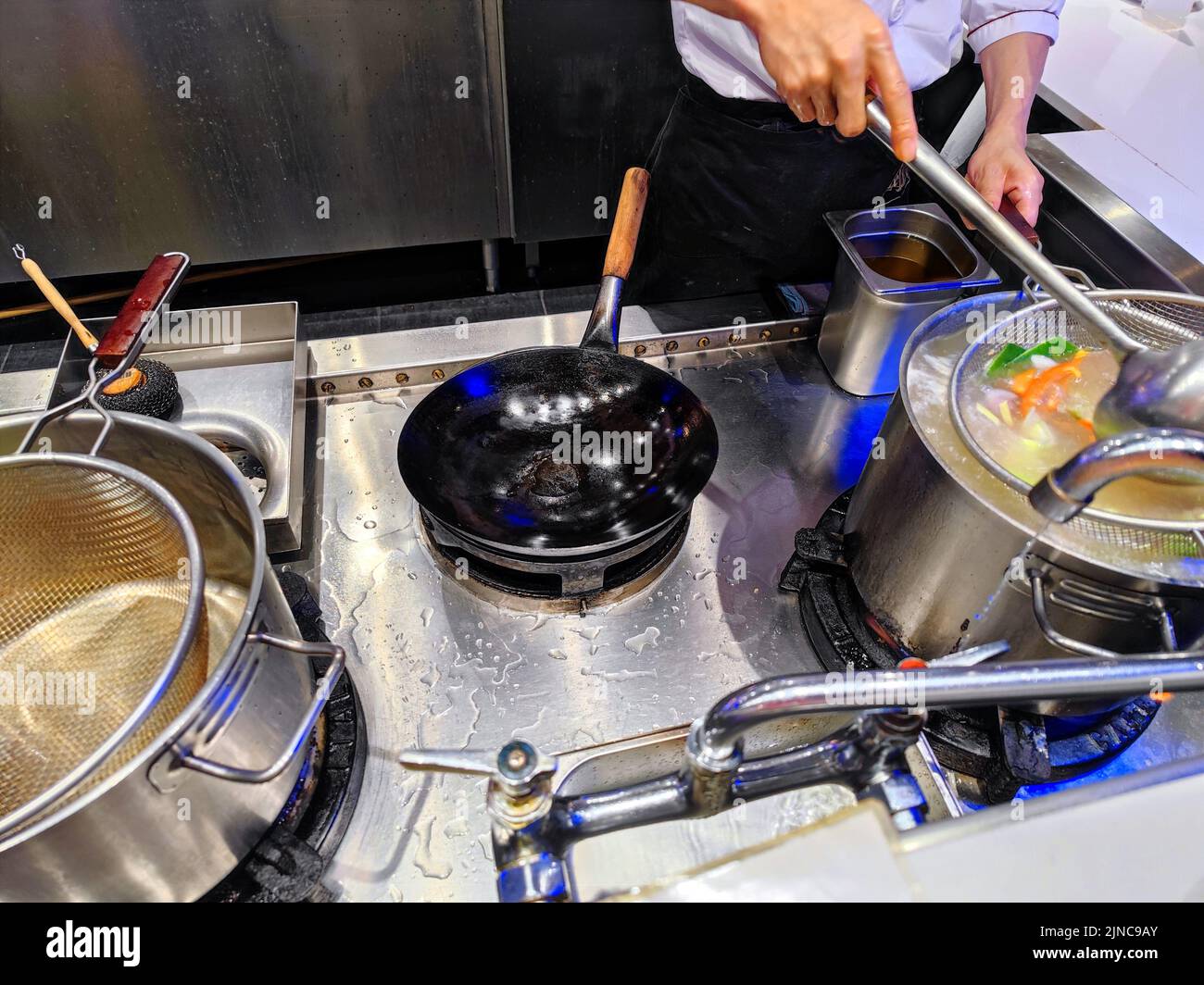 Vari tipi di verdure e carne in salsa asiatica vengono cucinati e pronti per essere mescolati fritti in una pentola wok Foto Stock