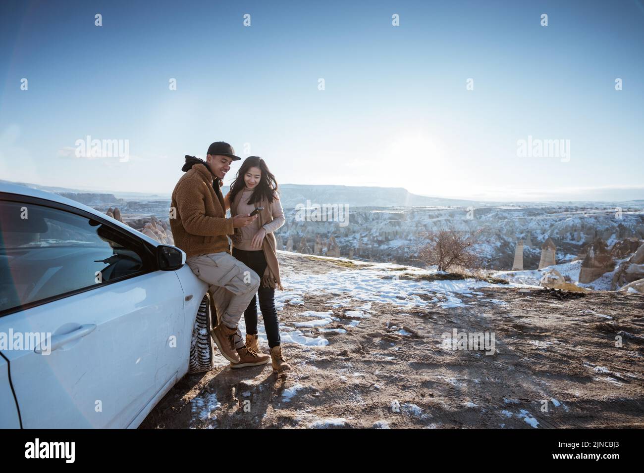 coppia asiatica fare avventura in auto guardando il telefono cellulare Foto Stock