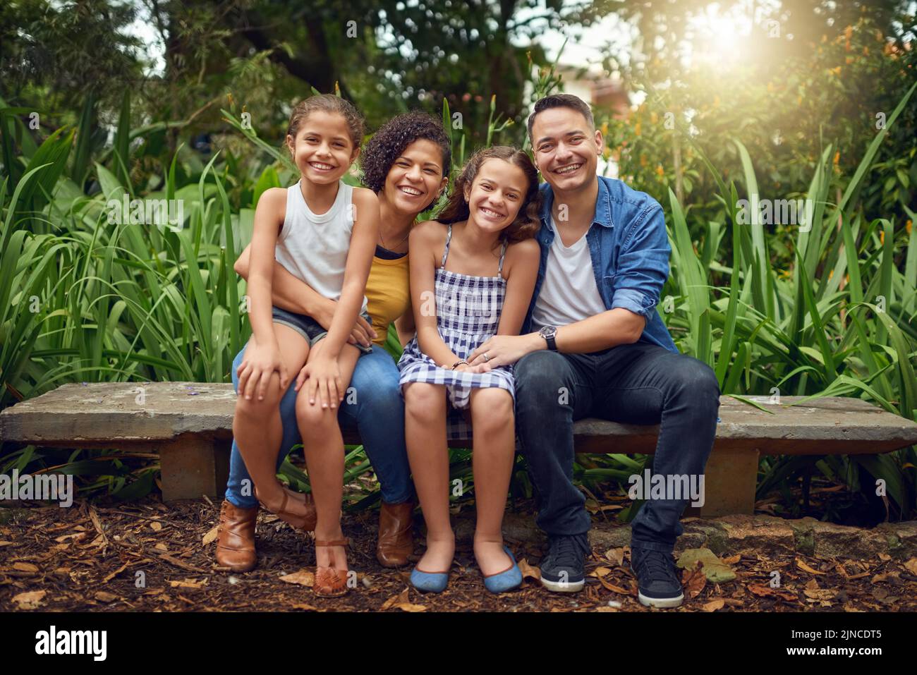 La famiglia è la cosa più vera della vita. Ritratto completo di una famiglia felice che trascorre un po' di tempo insieme su una panchina del parco. Foto Stock