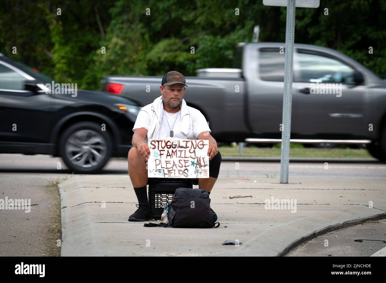 Cary, Carolina del Nord, Stati Uniti. 10th ago, 2022. Ed Chobot, 47 anni, si trova su una cassa vicino a un'uscita autostradale sperando in abbastanza donazioni per nutrire la sua famiglia per il giorno. Ha detto che il suo struco come falegname si è asciugato e hasnÃt è stato in grado di trovare lavoro nel corso dell'ultimo anno. (Credit Image: © Robin Rayne/ZUMA Press Wire) Foto Stock