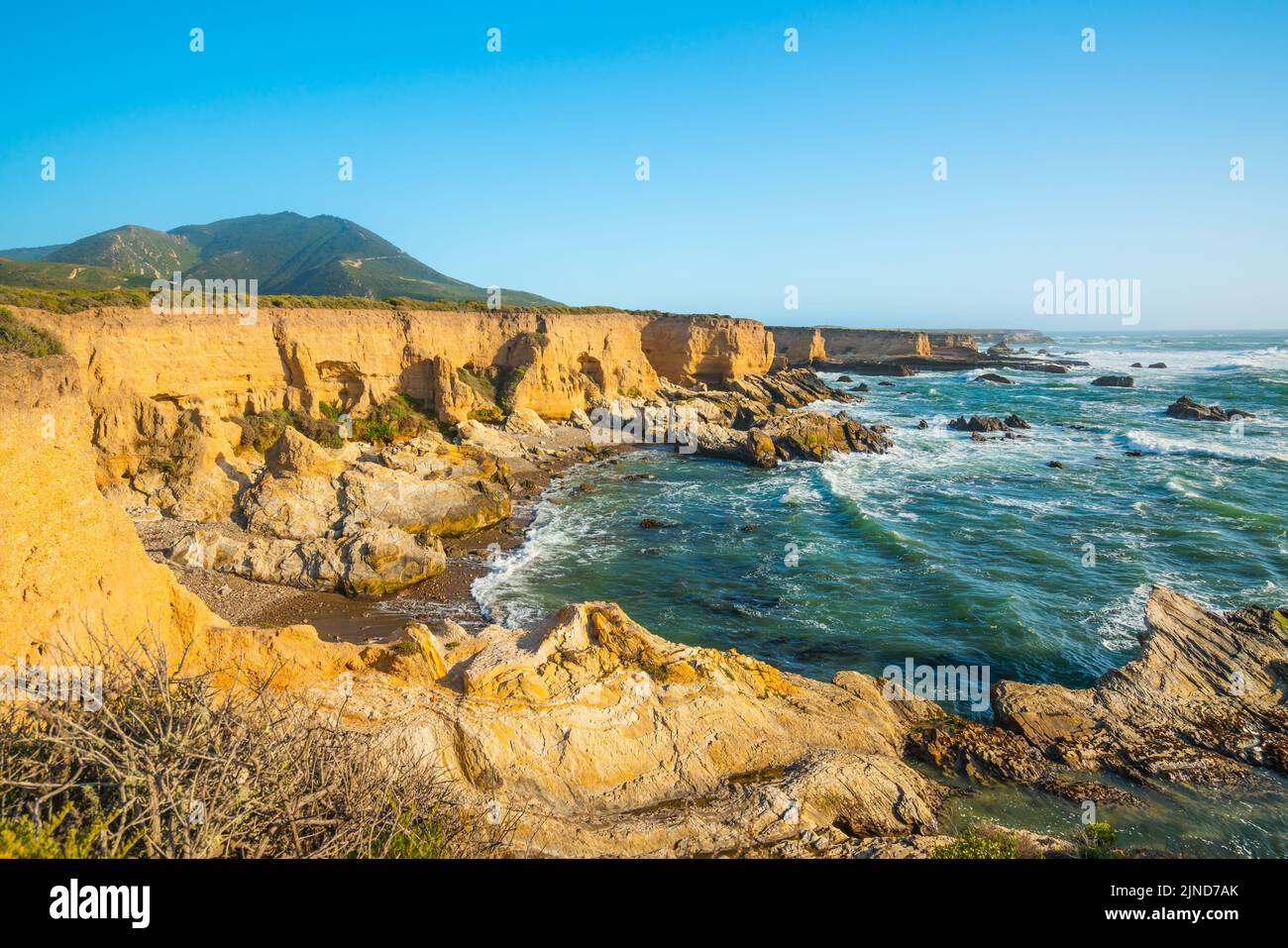 Scogliere rocciose vicino all'oceano., acqua di colore turchese e cielo blu chiaro Foto Stock