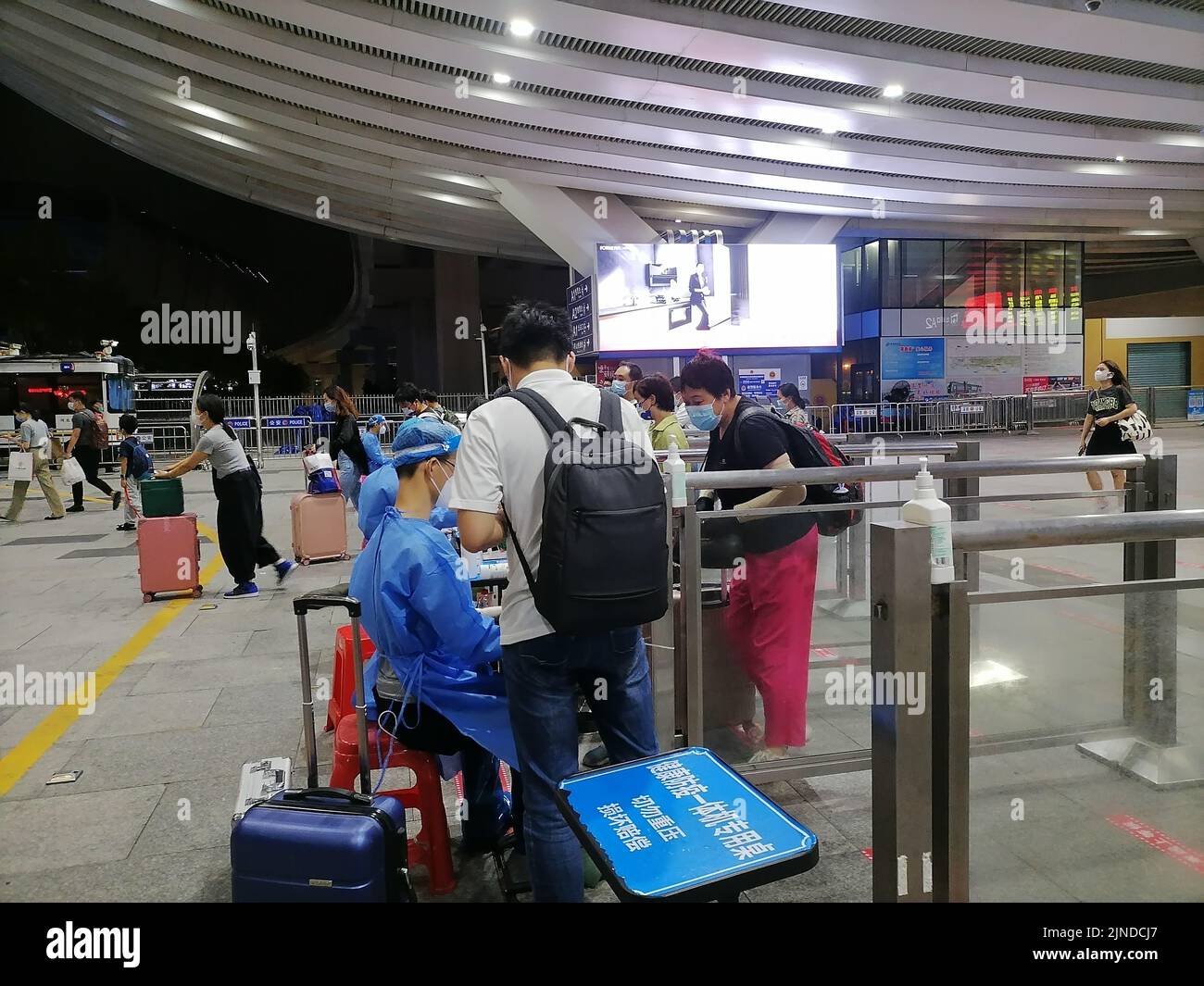Shenzhen, Cina: I passeggeri che entrano a Shenzhen con la ferrovia ad alta velocità devono avere un codice verde di rilevamento di acido nucleico di 48 ore. A1 il personale di uscita sta verificando il Foto Stock