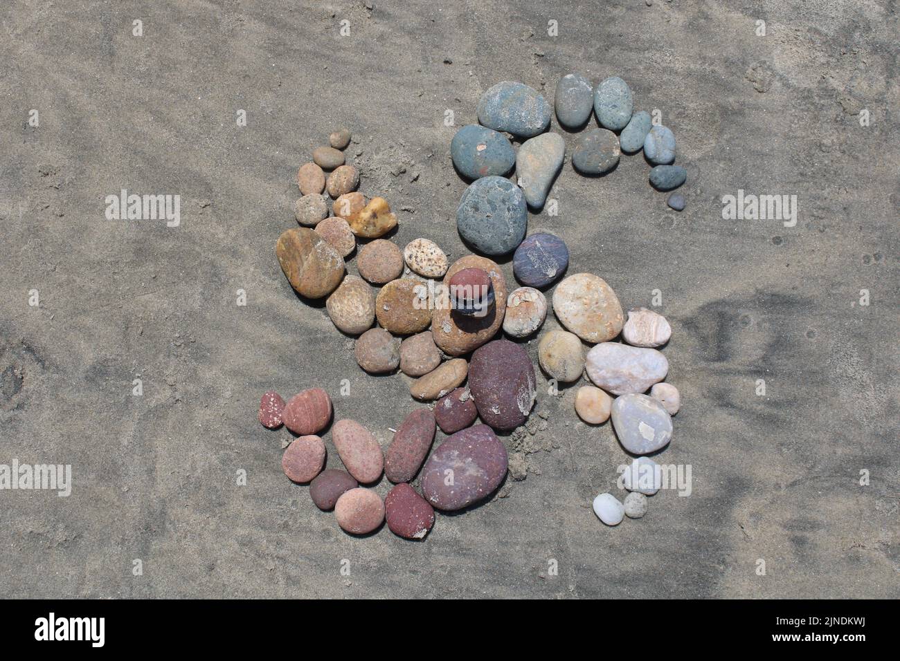 Una colorata spirale di pietre su una spiaggia sabbiosa della California meridionale. Caldo, soleggiato, e molto bella giornata nel mese di agosto. Foto Stock