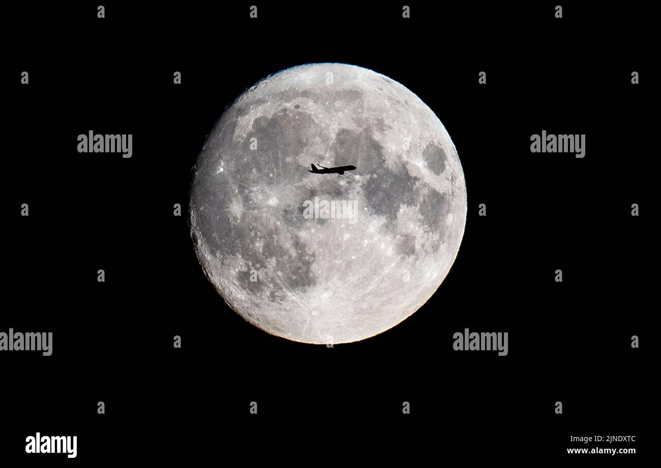 Londra, Regno Unito -10/08/2022. Un volo Ryan Air da Shannon a Budapest attraversa la Luna piena di Sturgeon su Londra Est. Foto Stock