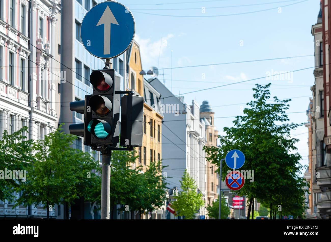 semaforo con semaforo verde sullo sfondo della strada urbana sfocata, primo piano Foto Stock