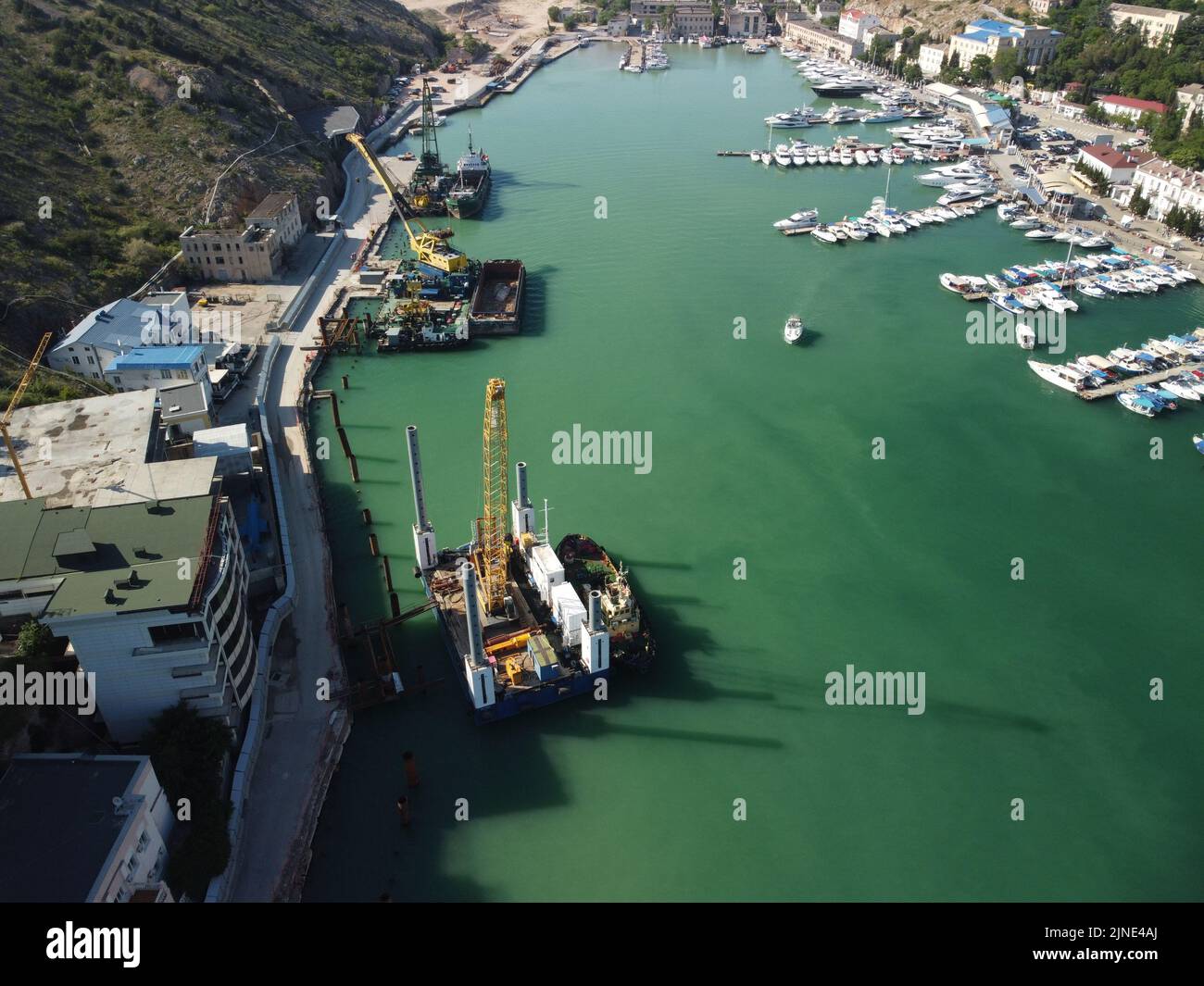 Carroponte galleggiante che dragano chiatte che lavorano per la costruzione di un porto turistico. Vista dall'alto dell'antenna Foto Stock
