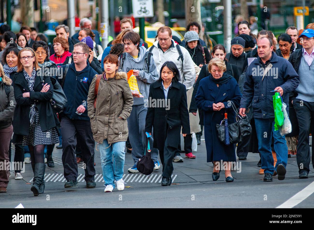 I pendolari di Melbourne che si dirigono verso la stazione ferroviaria di Flinders Street dopo il lavoro in una giornata invernale Foto Stock