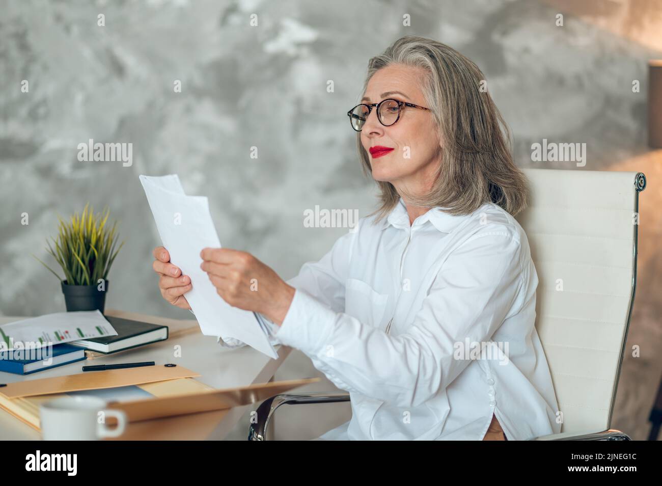 Donna d'affari ben vestita e bella in ufficio Foto Stock