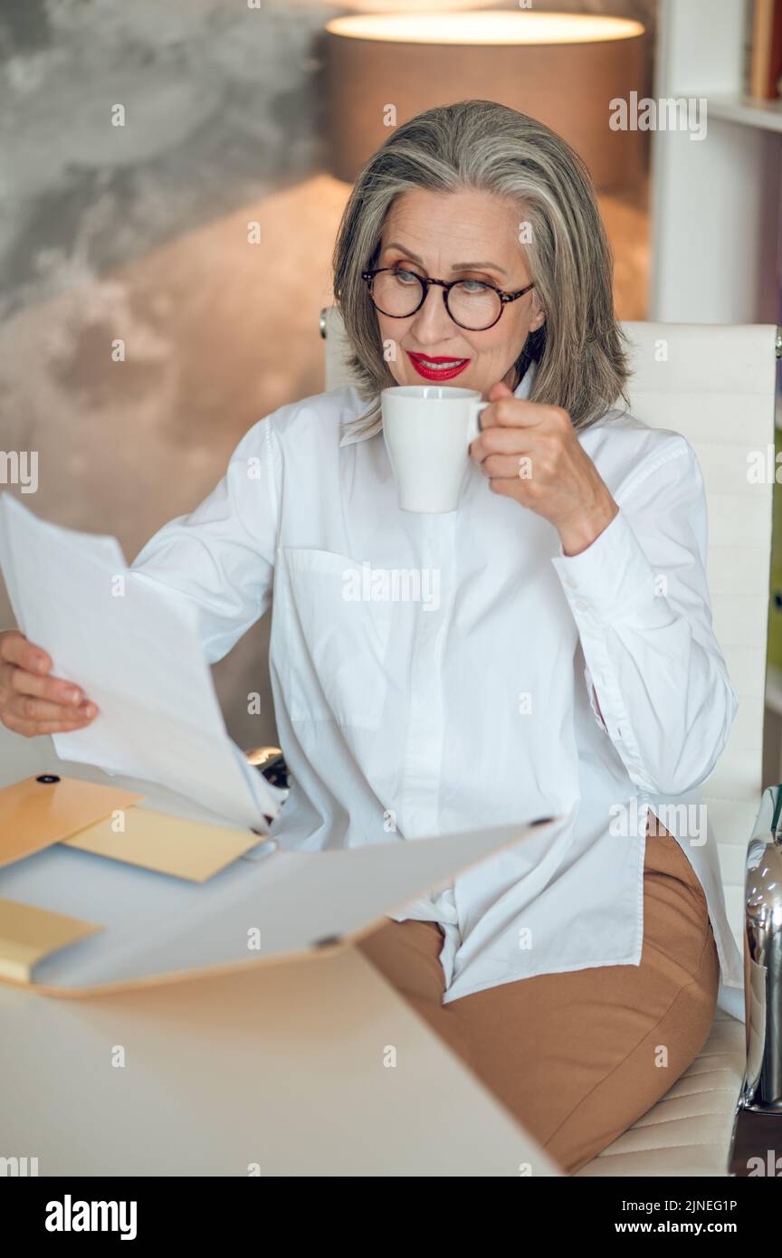 Donna d'affari ben vestita e bella in ufficio Foto Stock