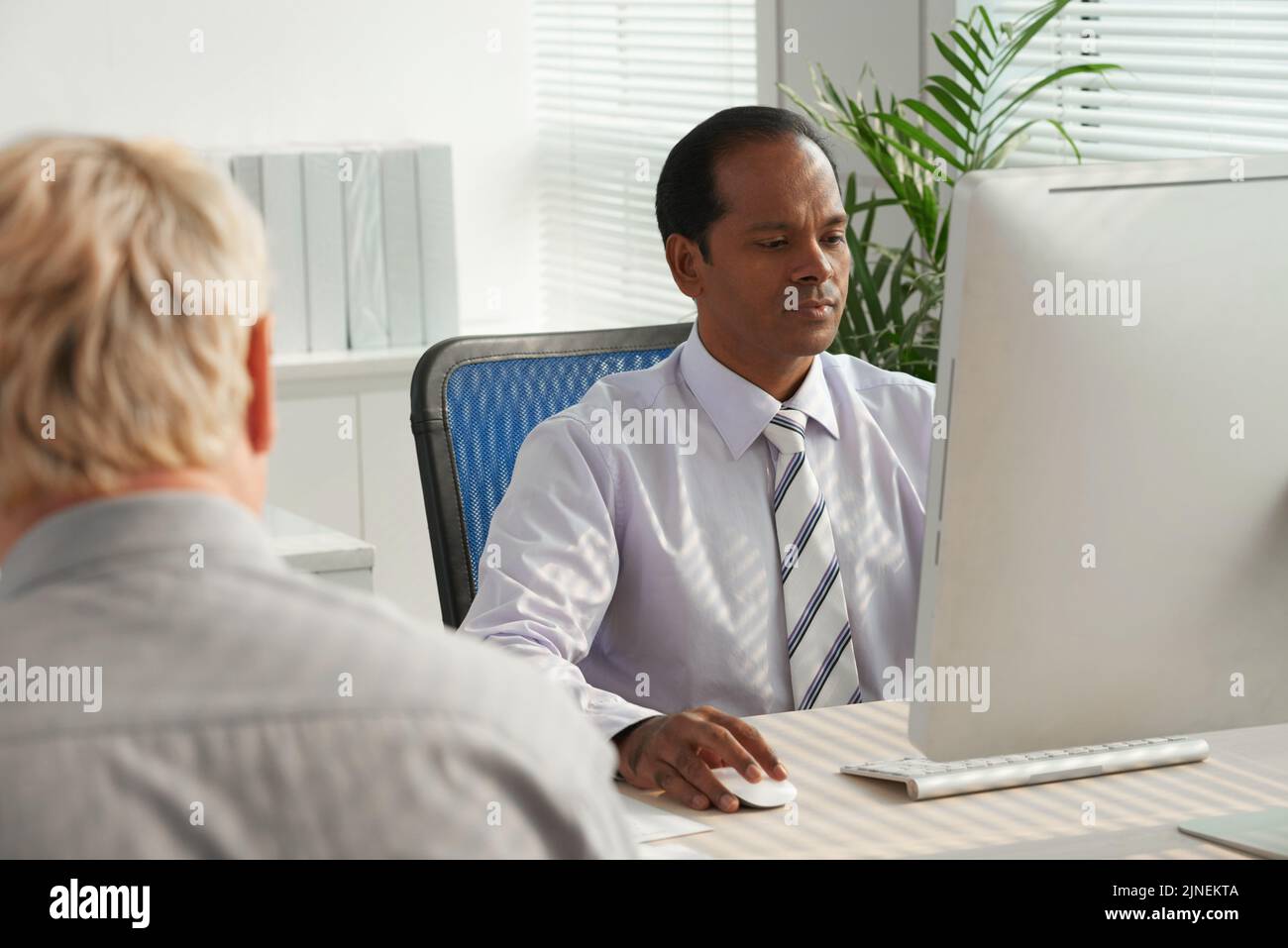 Imprenditore indiano che lavora al computer al suo tavolo Foto Stock